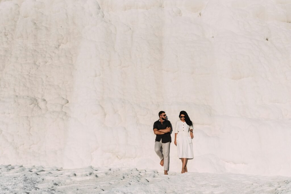 Guy and girl standing against the wall and posing in front of the camera. Wedding trip